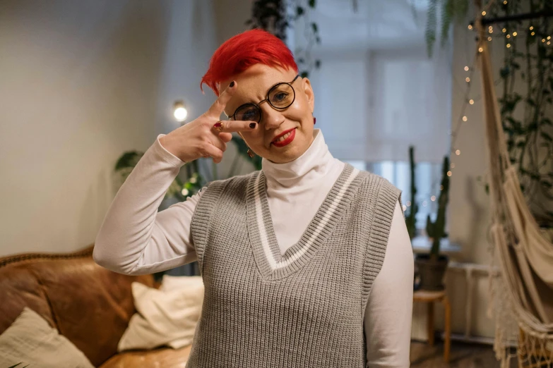 a woman with bright red hair holding glasses