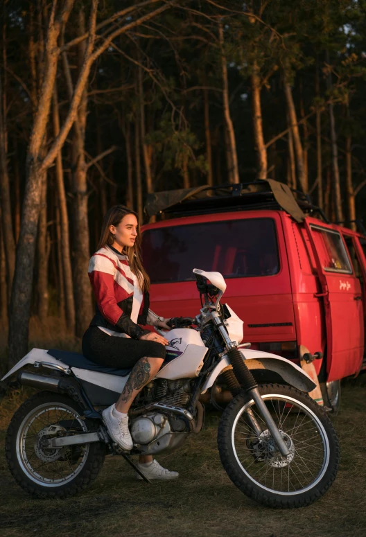 a woman sitting on a motor bike in front of a red truck
