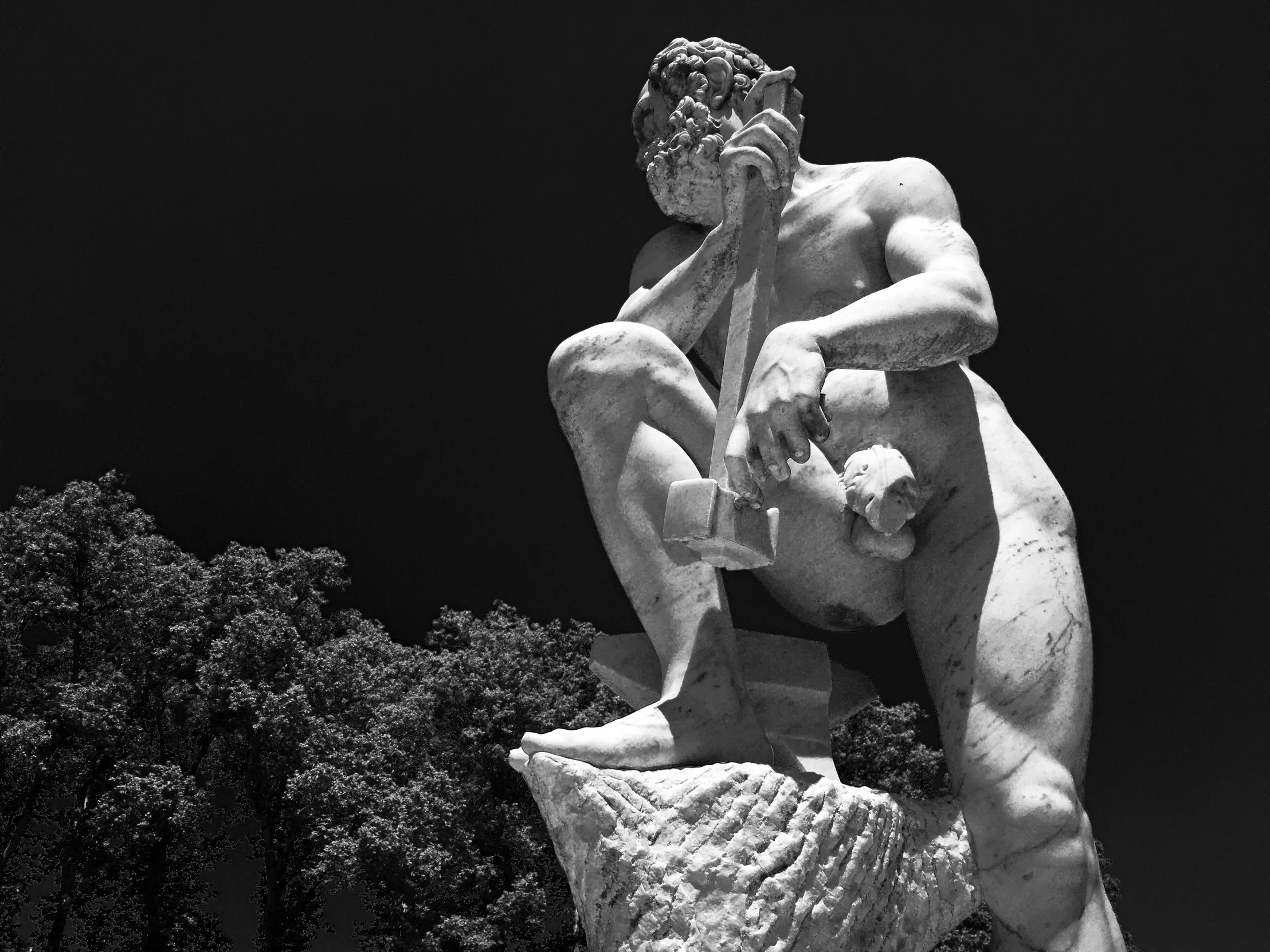 a statue of a man sitting on top of a stone