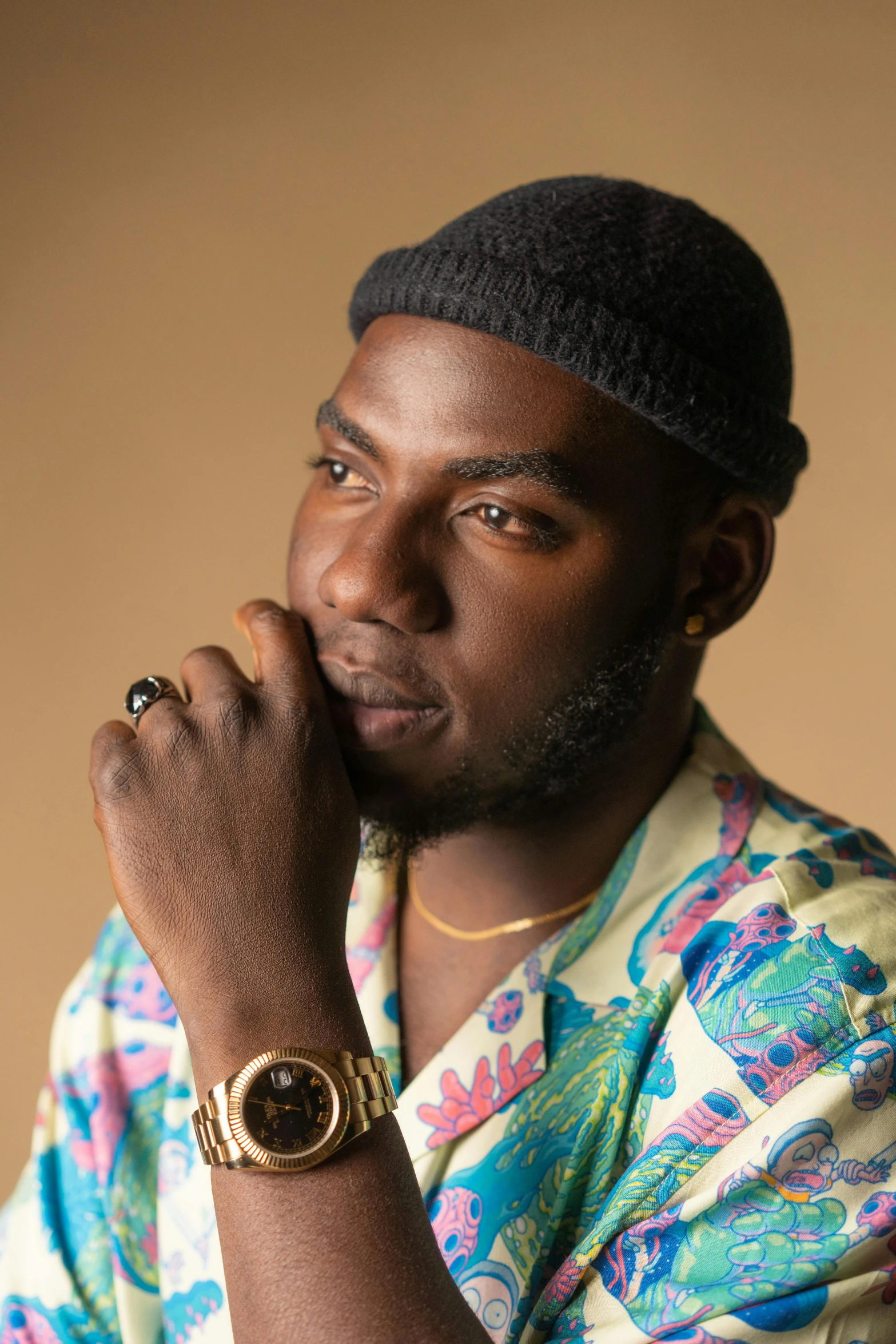 a black man sitting with his hand on his chest