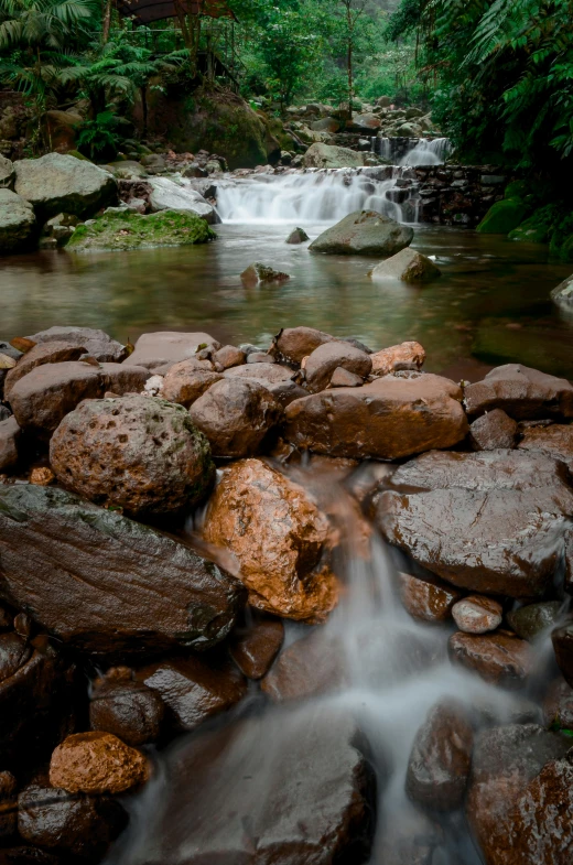 a small waterfall surrounded by rocks and trees