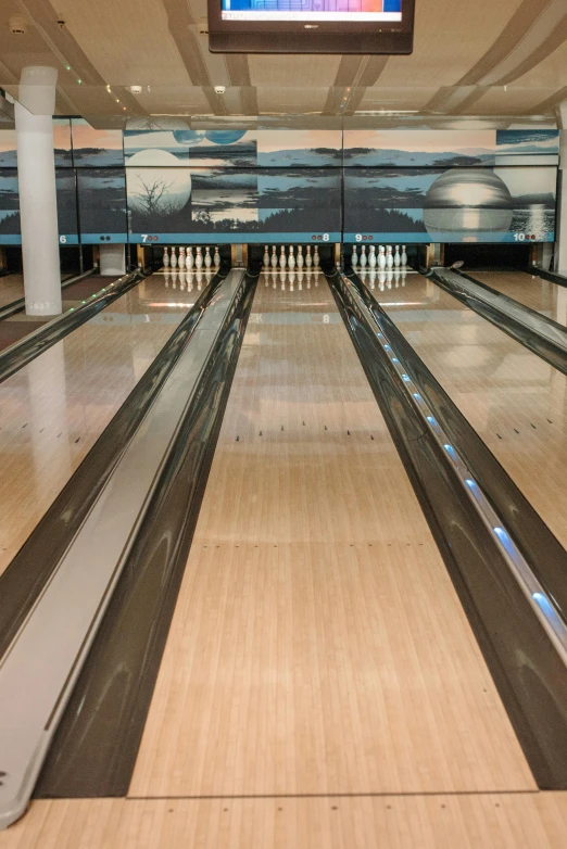 an empty bowling court has lanes full of bowling balls