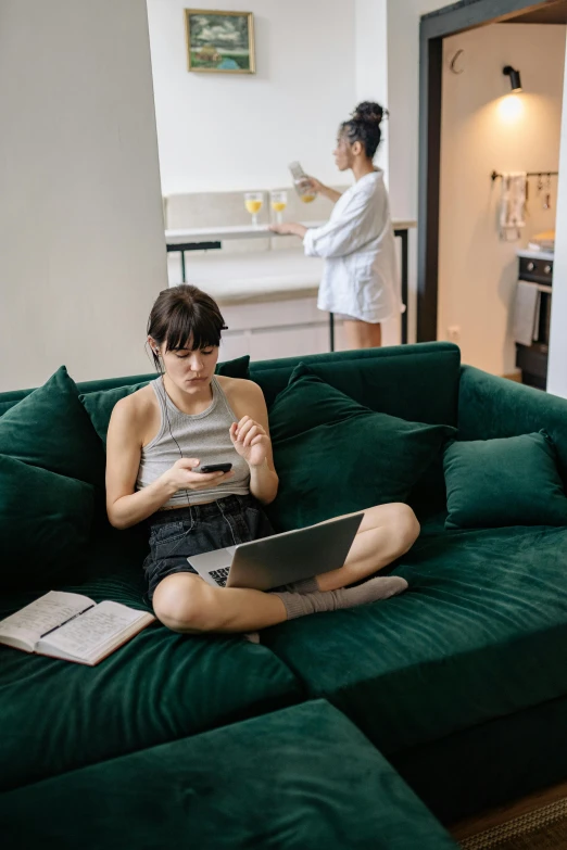 a woman sitting on top of a green couch