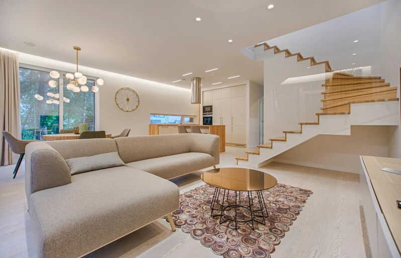 a couch sitting on top of a rug next to a stairway