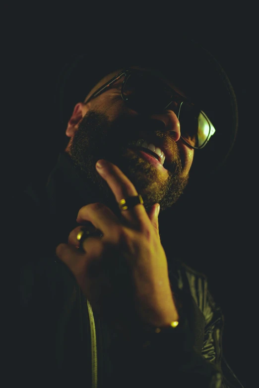 a man wearing glasses and a hat is talking on the phone