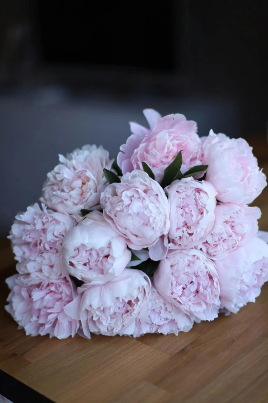 pink flowers are arranged on a table with white cups