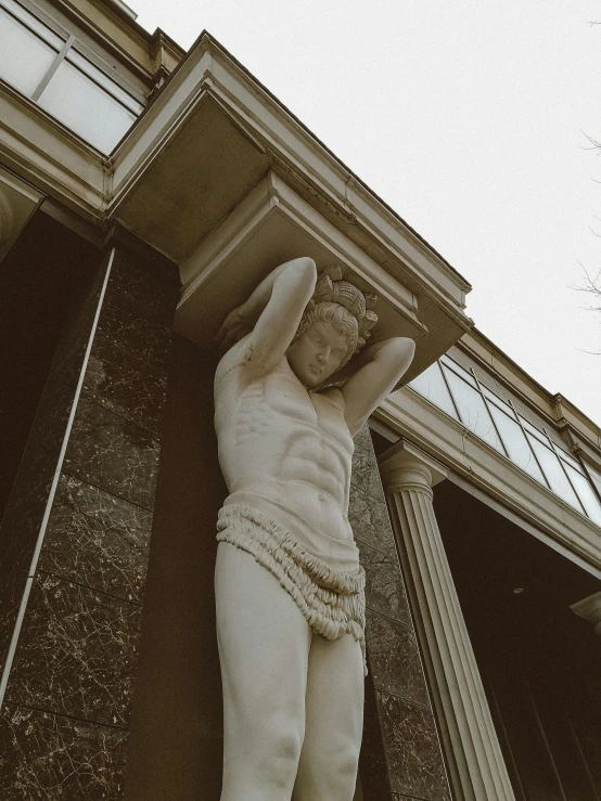 a statue on the side of a building with a sky in the background