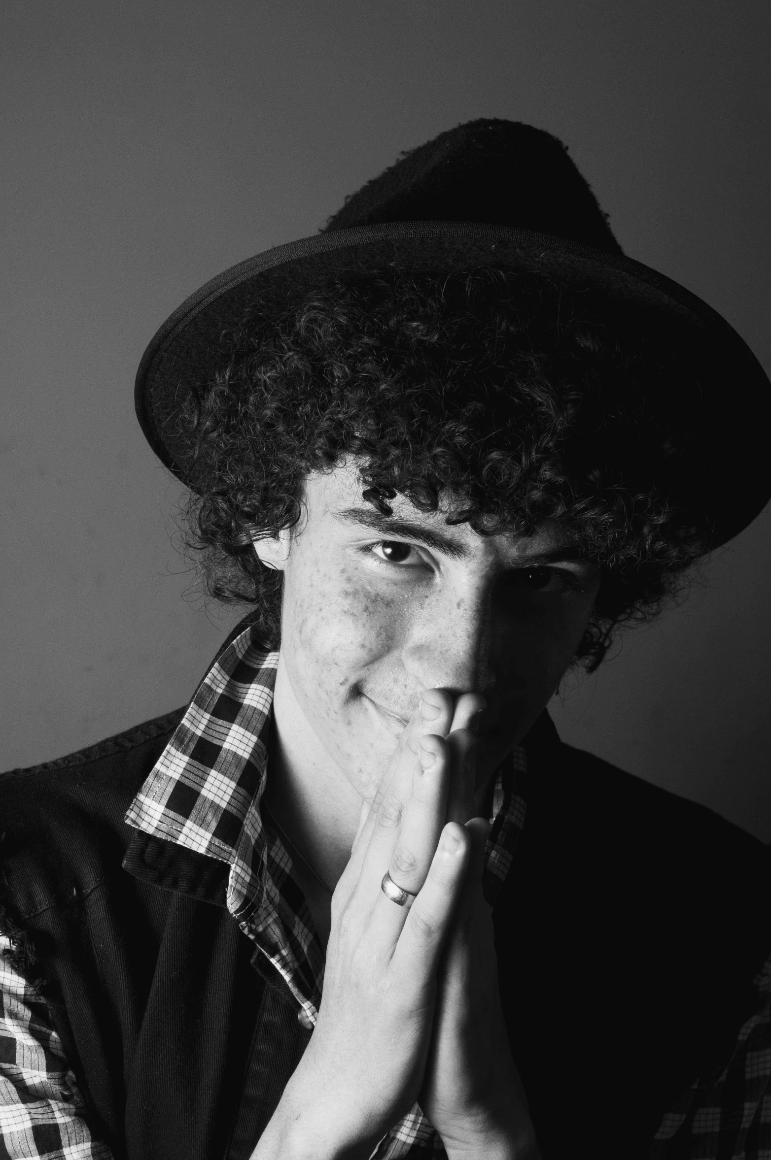 a man with a weird afro wig in a black hat posing for the camera