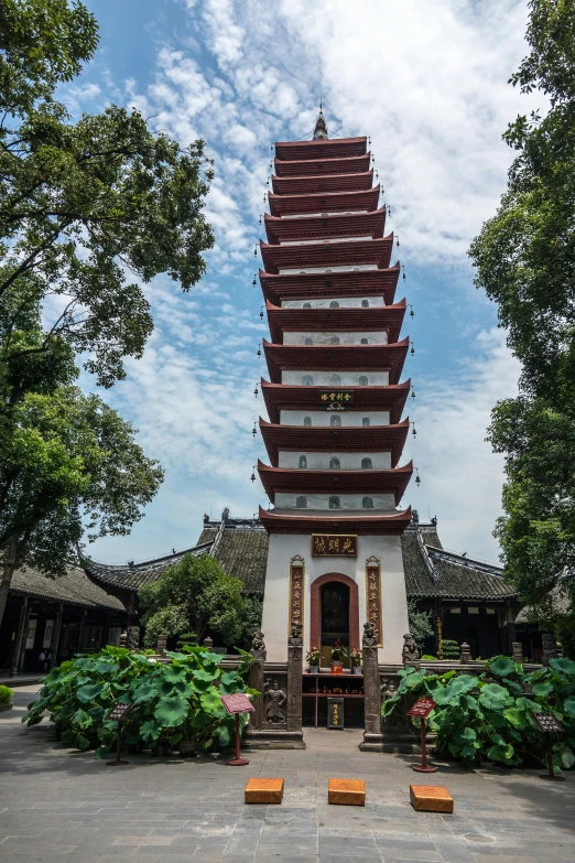 a large pagoda tower surrounded by plants and flowers