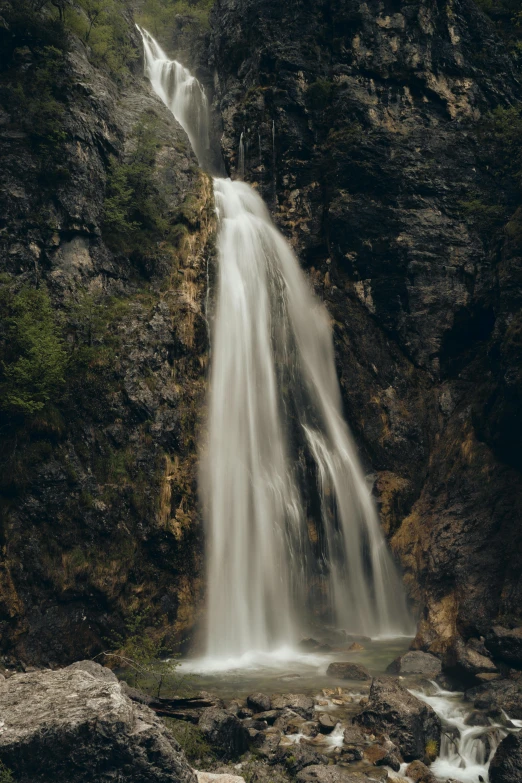 there is a waterfall in the middle of the mountain