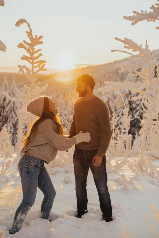 a couple dance in the middle of snow covered forest