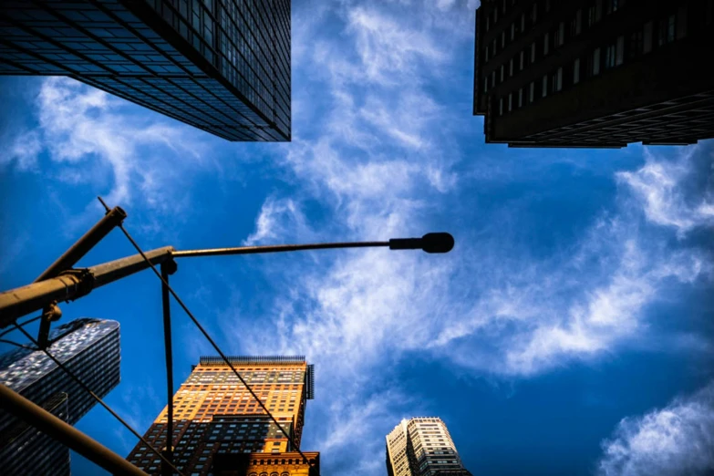 tall buildings under a cloudy sky, with a street light