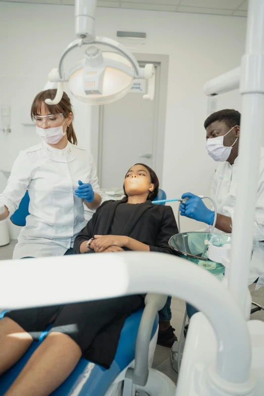 three dentists working on a child in a dental office