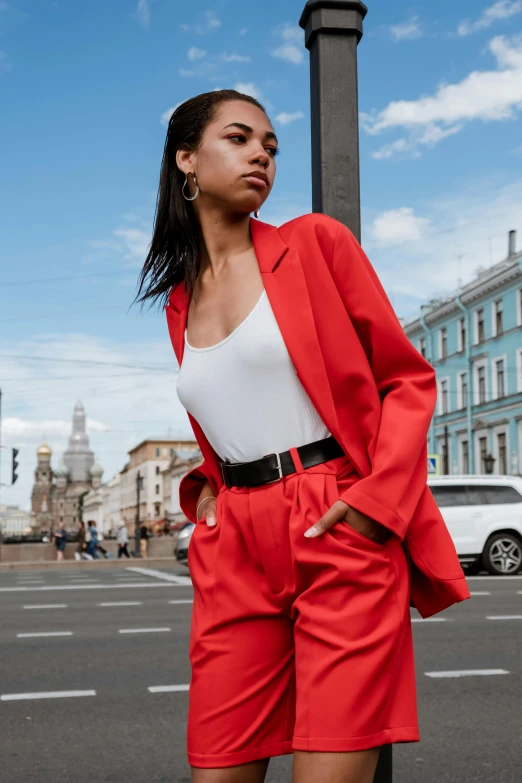 a woman in an orange jacket and red shorts