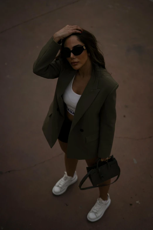 a woman holding her hair and posing on top of a roof