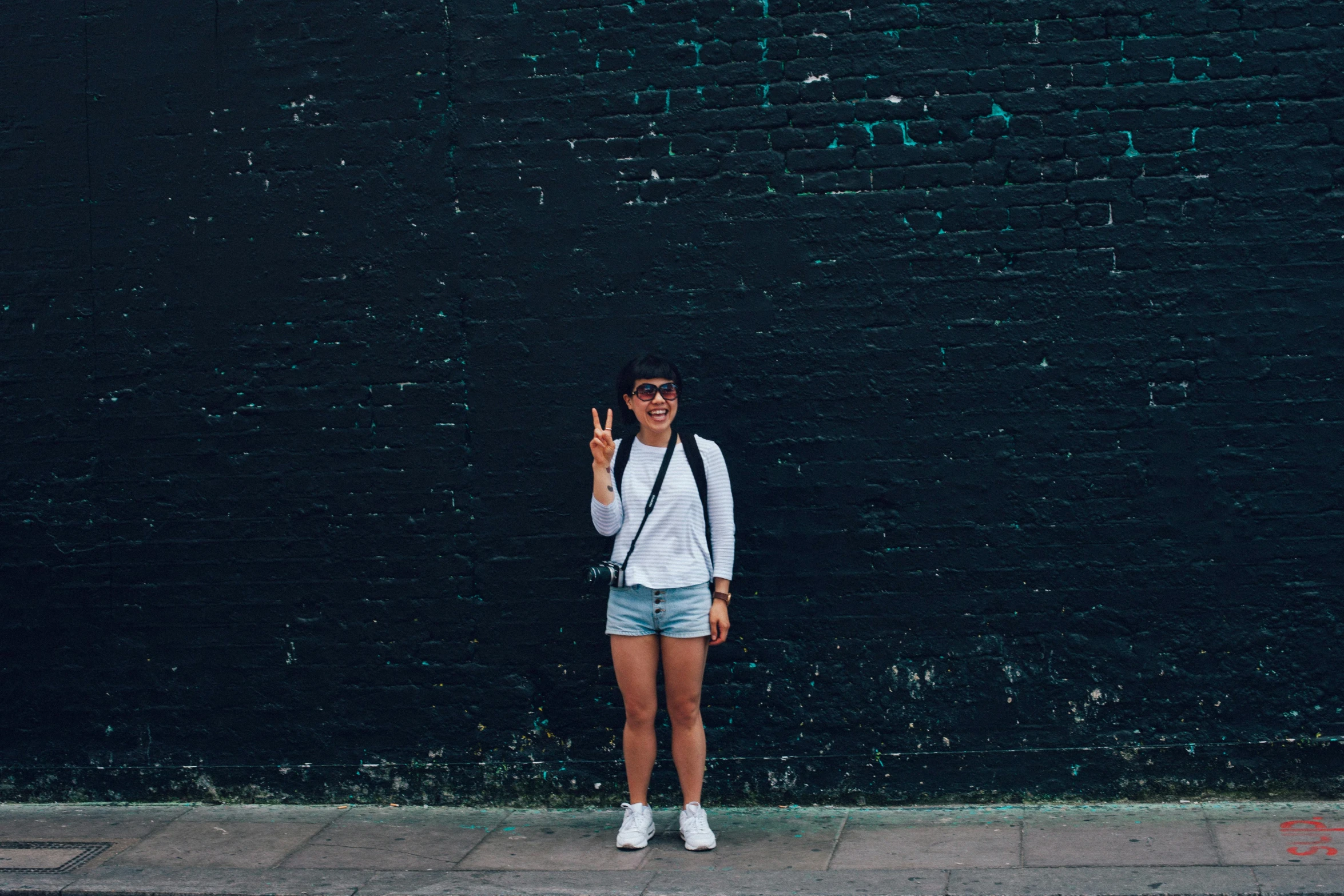 a man is standing next to a black wall