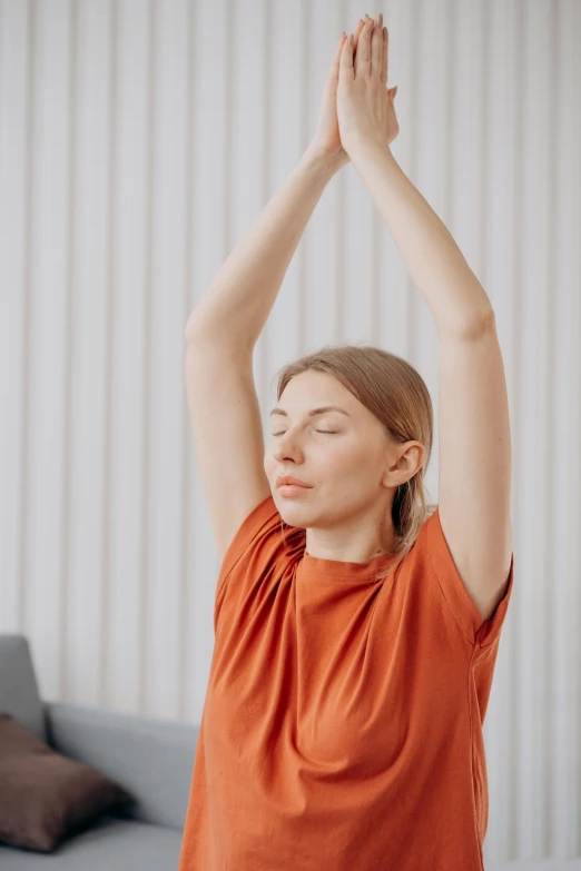 a woman standing on one leg with her hands in the air