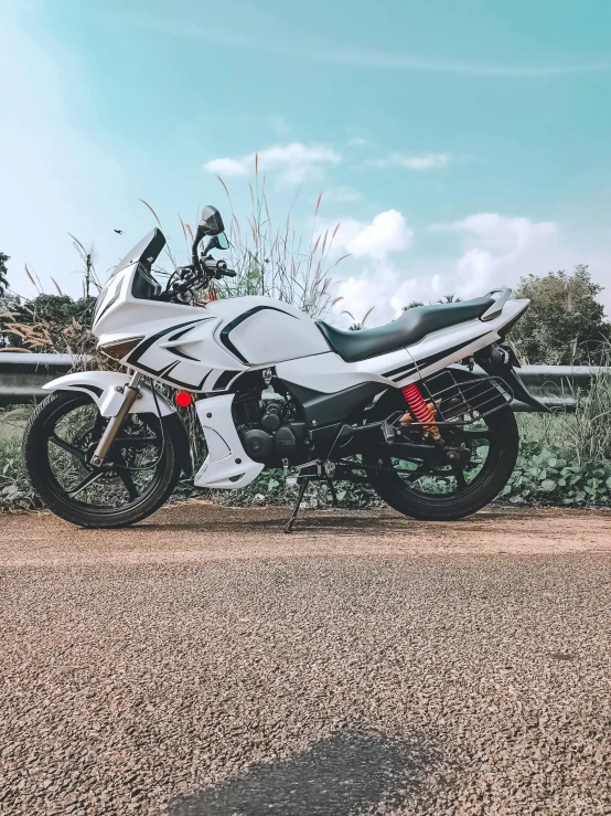 motorcycle parked by fence on dirt road in rural area