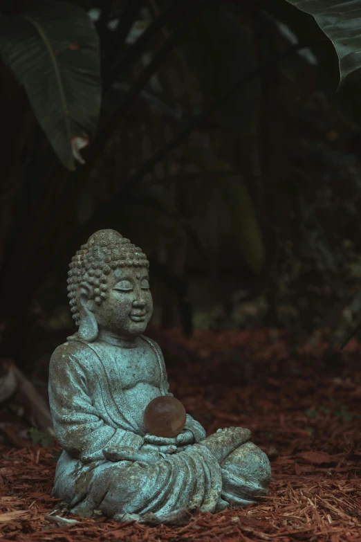 a buddha statue sitting on top of some brown straw