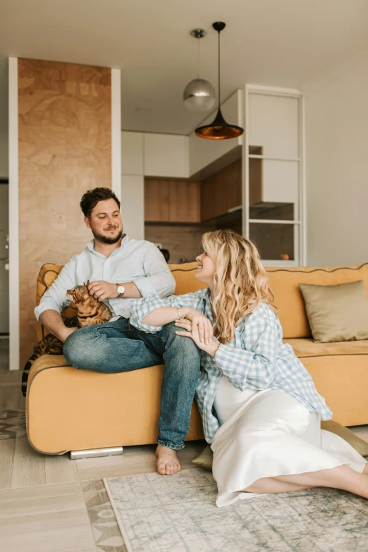 two people sitting on couches with the woman holding a dog