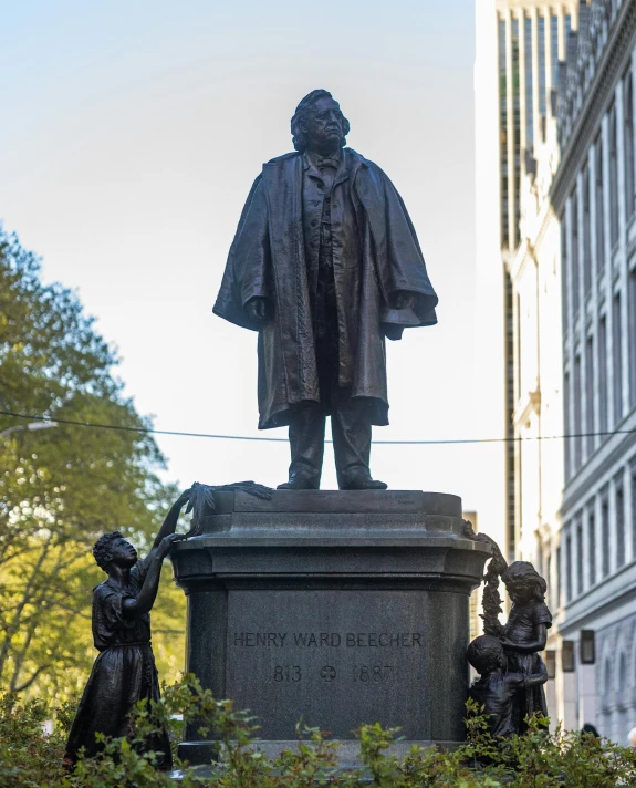 a statue of a man standing with two statues near by