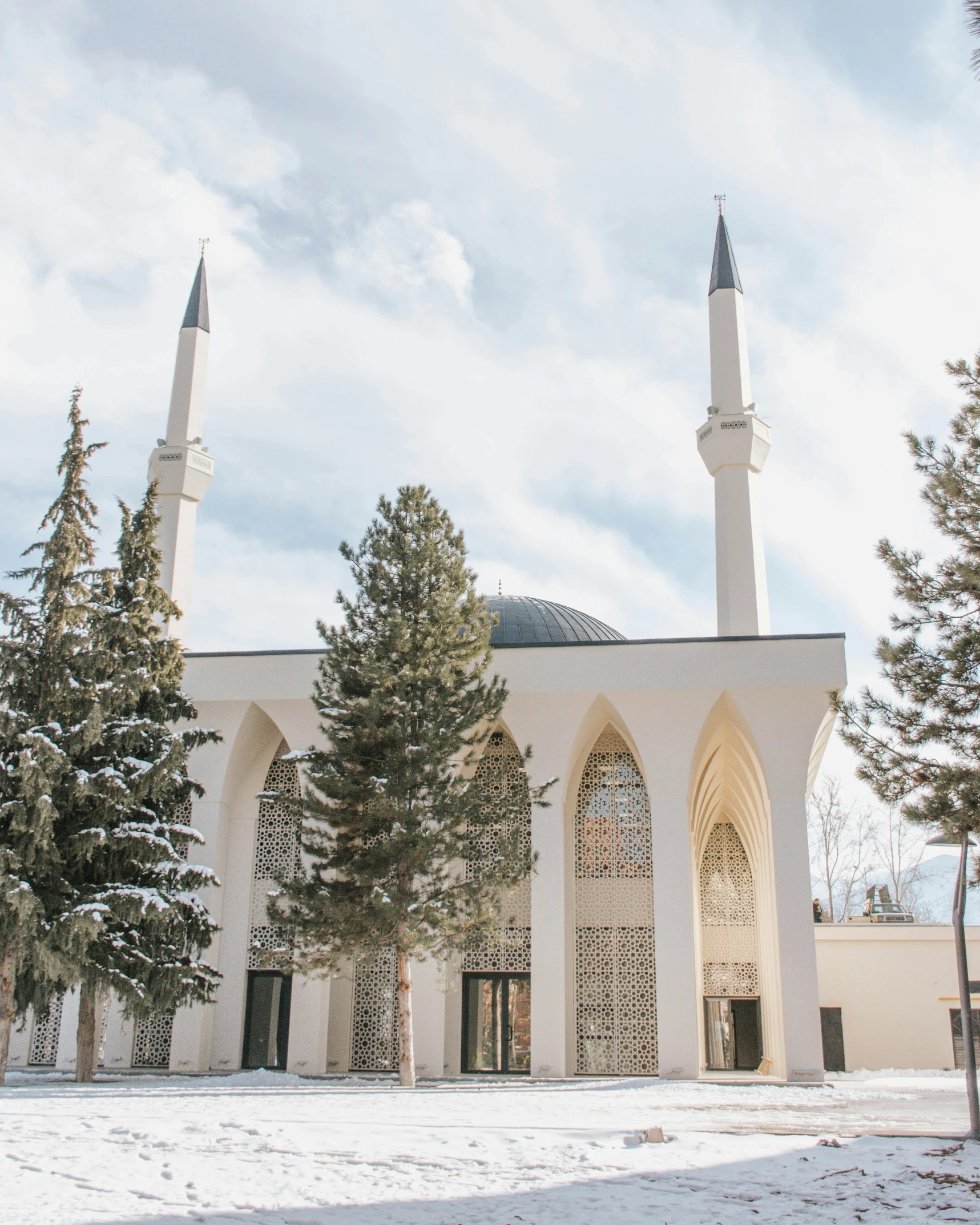 an islamic building is surrounded by snowy trees