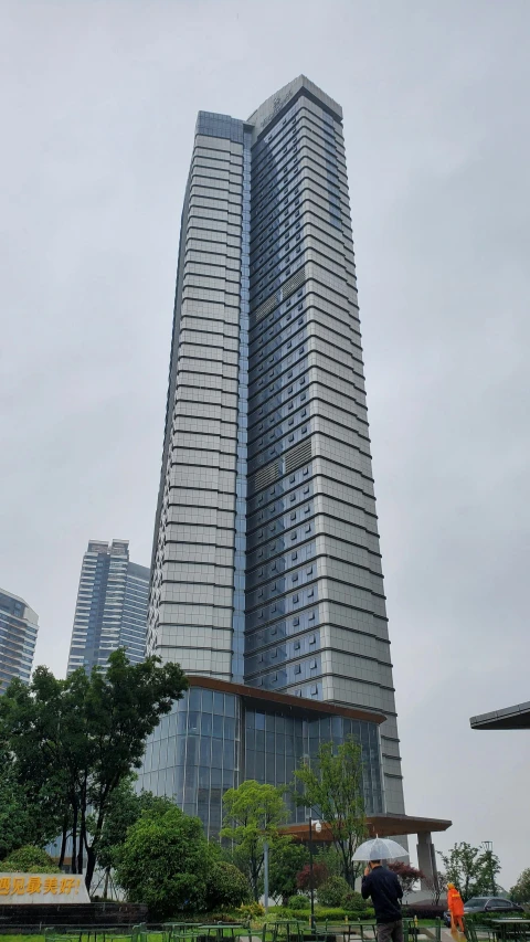 two people standing outside of a building with a lot of windows