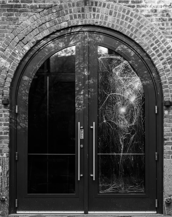 a black and white po of a broken glass door