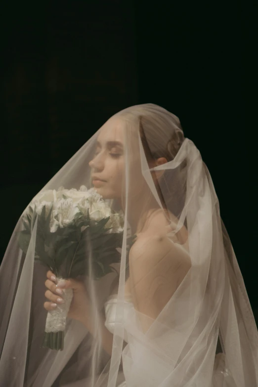the veil and flower detail of a wedding dress are visible