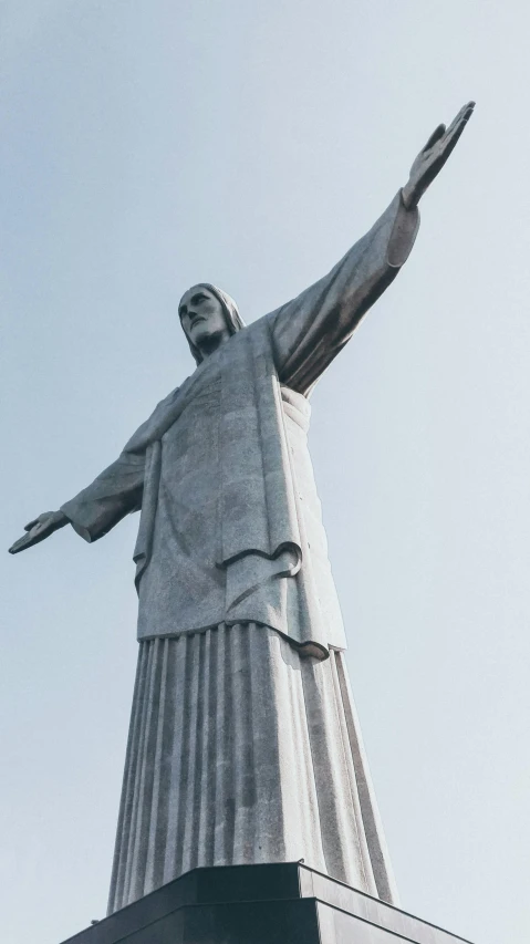 the statue of jesus in front of a blue sky