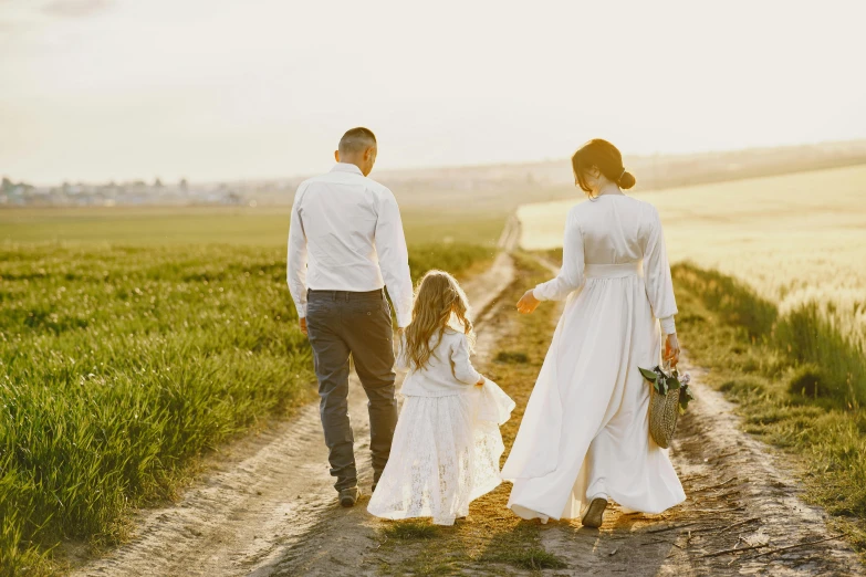 an adult is walking with a small girl on the road