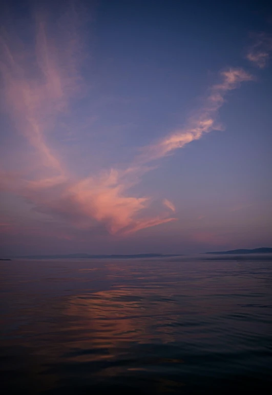 some clouds over the ocean at sunset