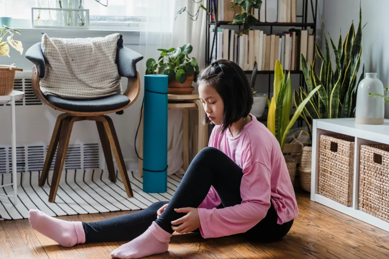 a  sitting on the floor next to her feet