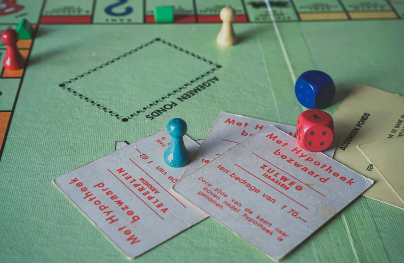 two red and blue blocks on the front of a monopoly board