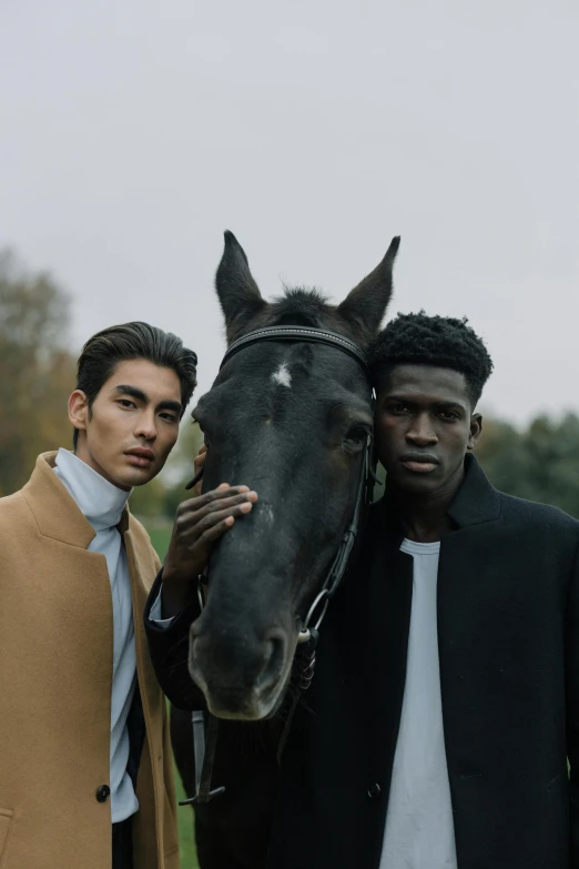 two young men stand with their horse