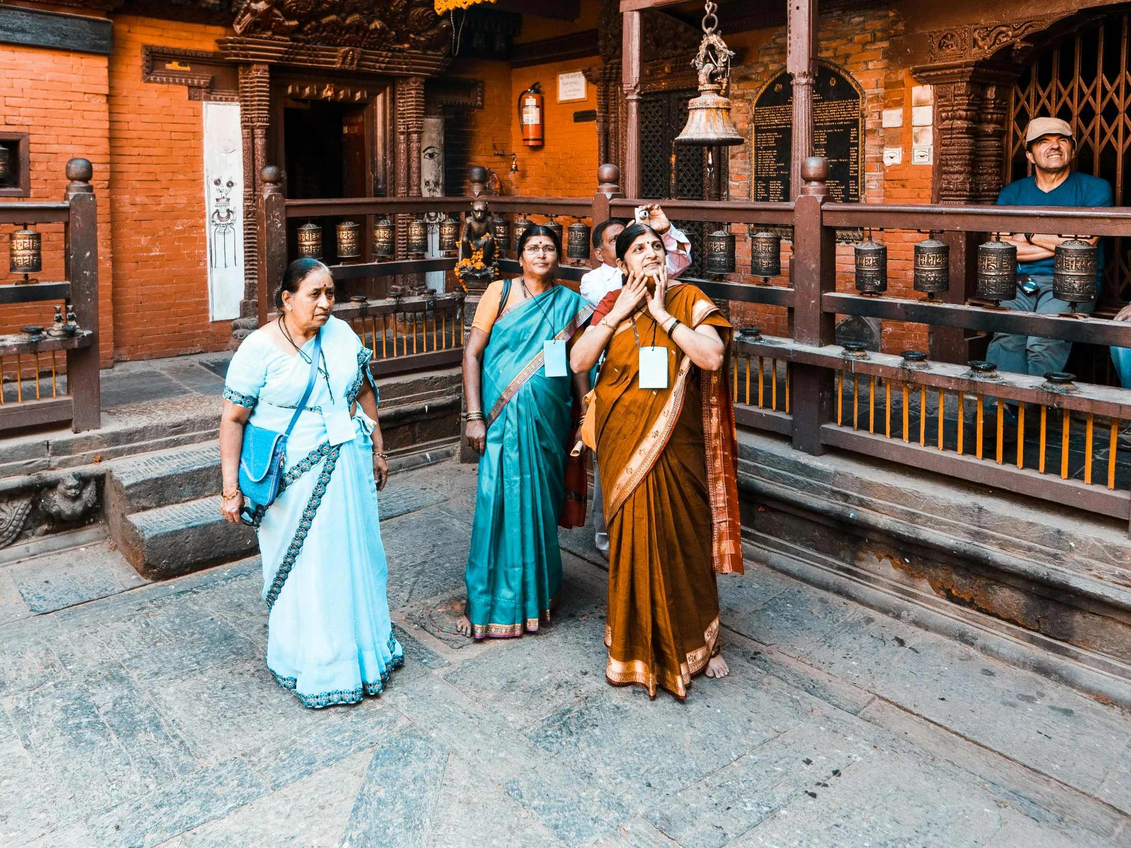 four ladies dressed in indian clothing stand together on the steps