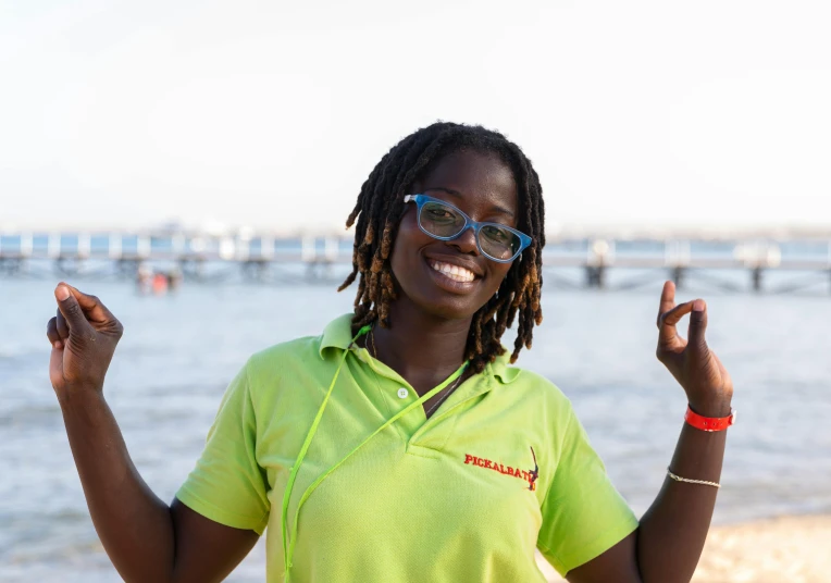 a lady in a yellow shirt and a pink shirt by the water