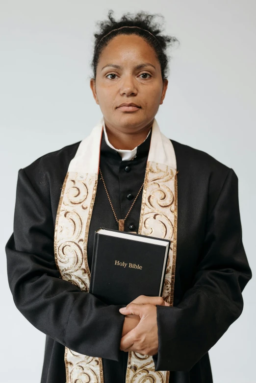 the priest is holding a small book in her hand