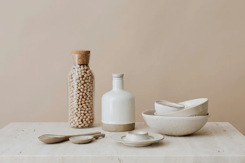 there is a bowl, salt shaker and bottle on the table