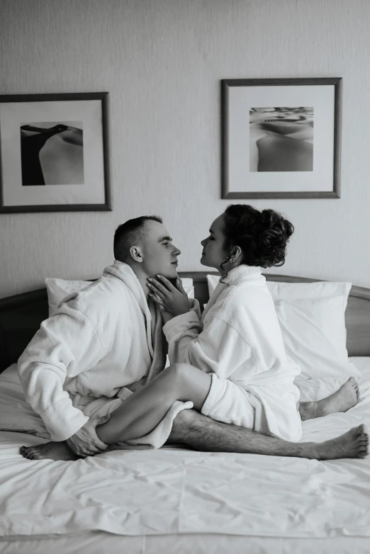 two people in robes on a bed