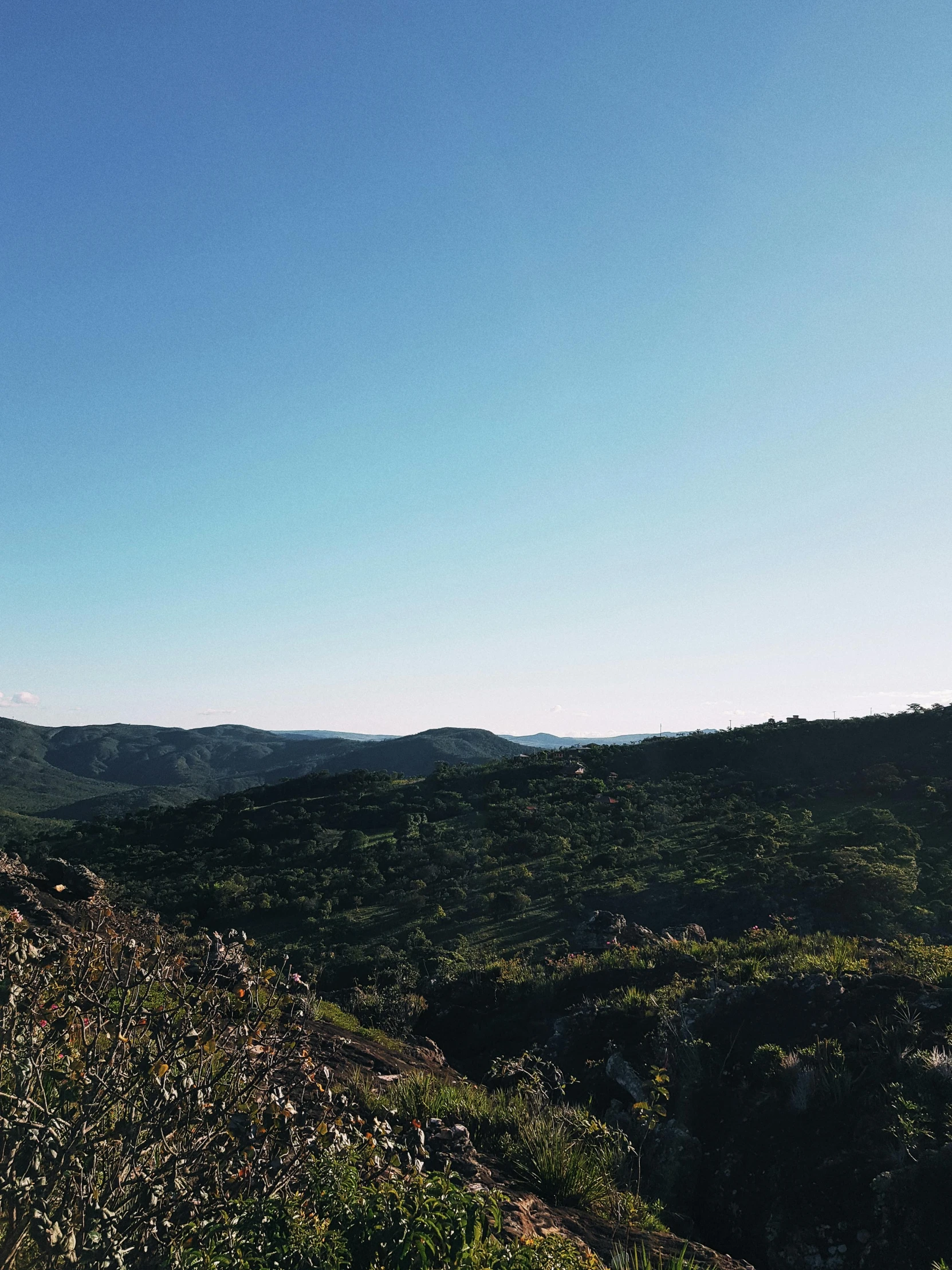 man sitting on a cliff edge with a sky background