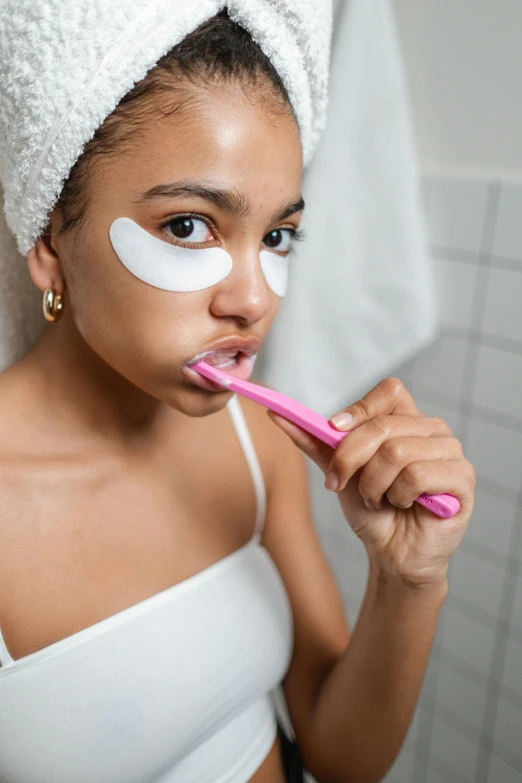 woman wearing bandaged face mask holding pink toothbrush