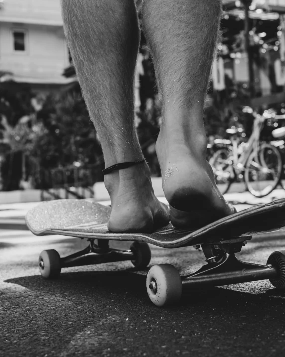 a person with sandals on riding on top of a skateboard