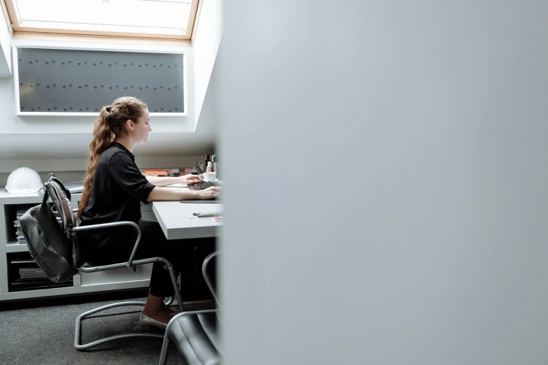 a woman sitting at a desk in front of a monitor