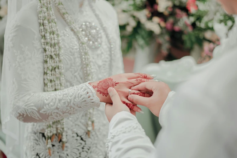 two people touching each other's hands with a flower in the background