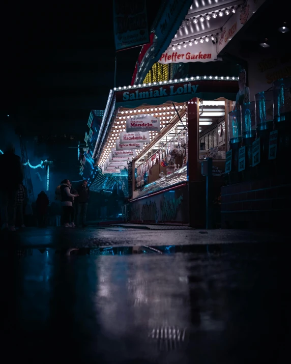 the outside of a carnival with a sign and people walking underneath it