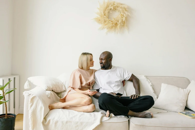 two people sit on the couch talking to each other