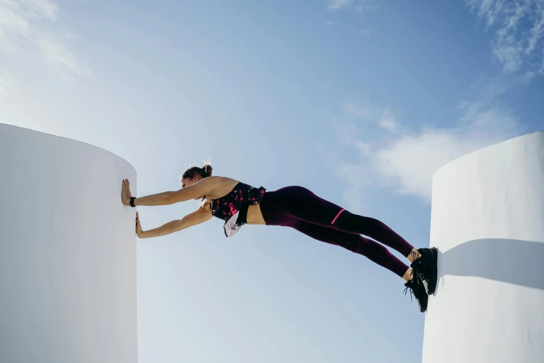 there is a woman on the top of a pole performing a trick