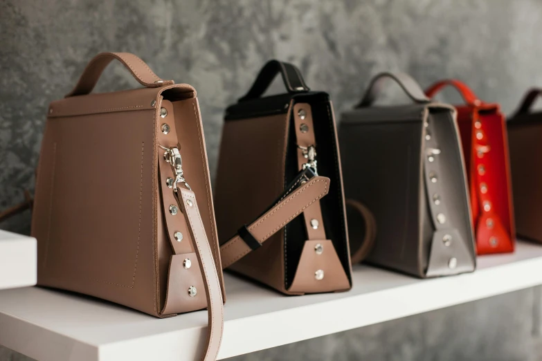 three different handbags sitting on a ledge next to each other