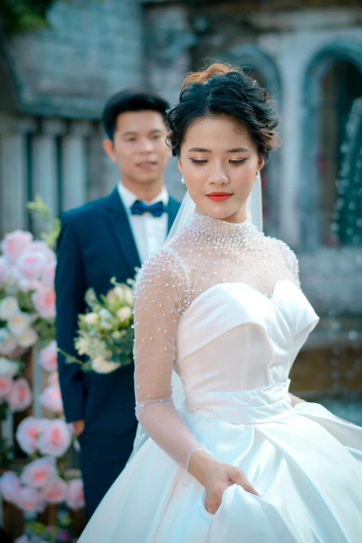 a couple stands near each other in their wedding gown